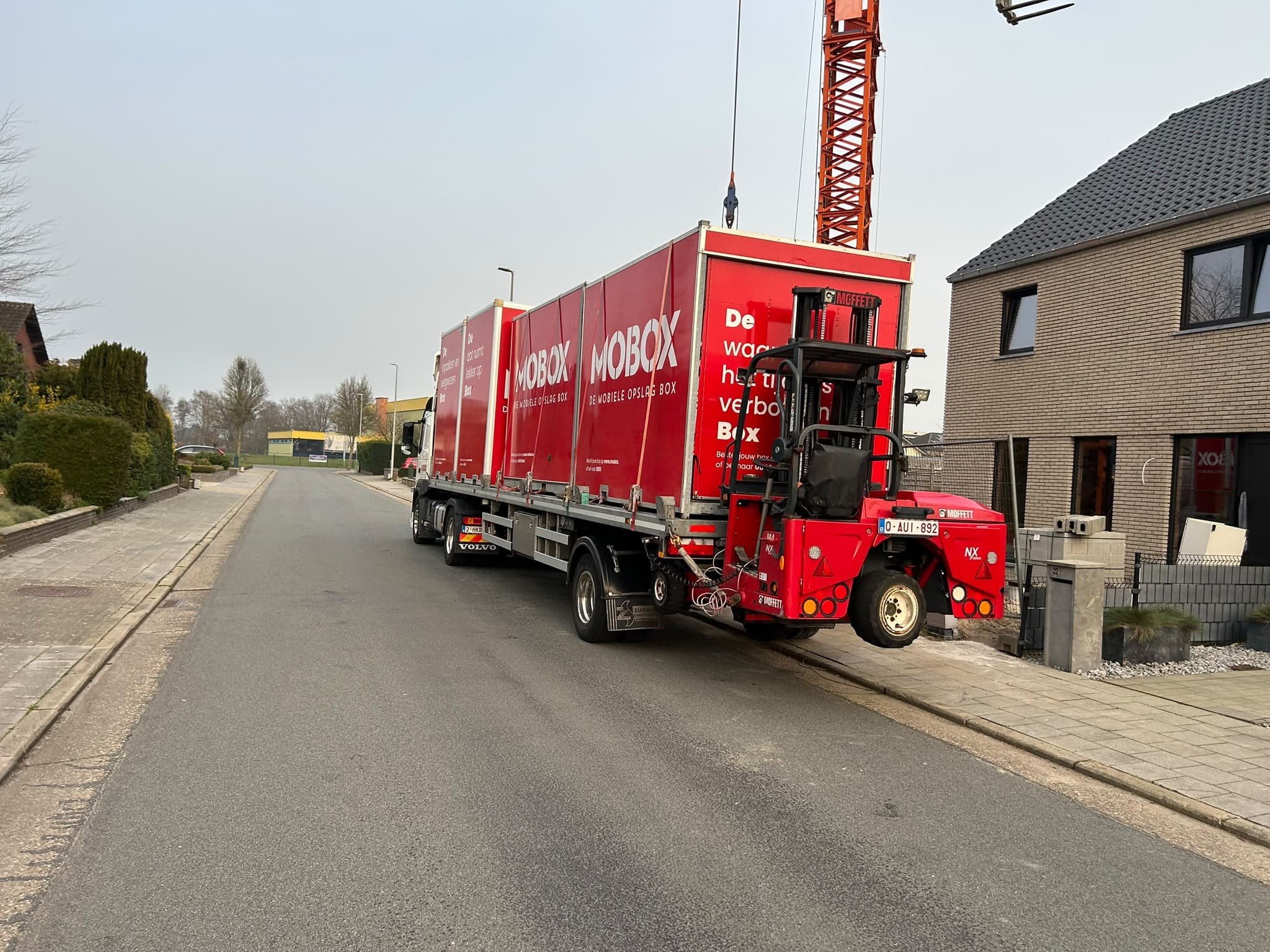 De heftruck lost een MOBOX-box van de vrachtwagen in een woonstraat